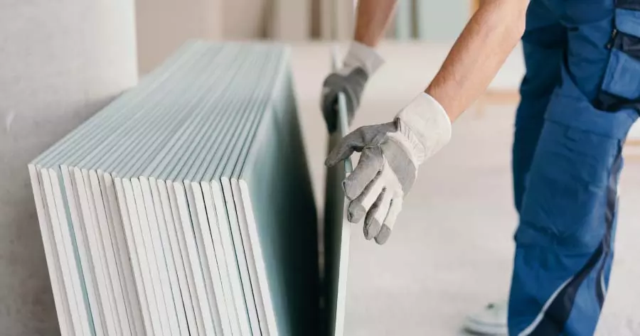trabajador cogiendo una lámina de pladur
